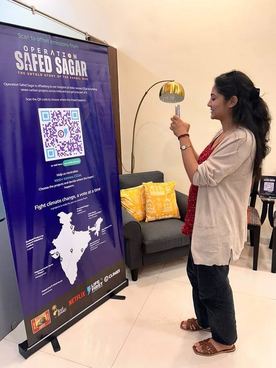 Crew member scanning the Operation Safed Sagar voting standee on set